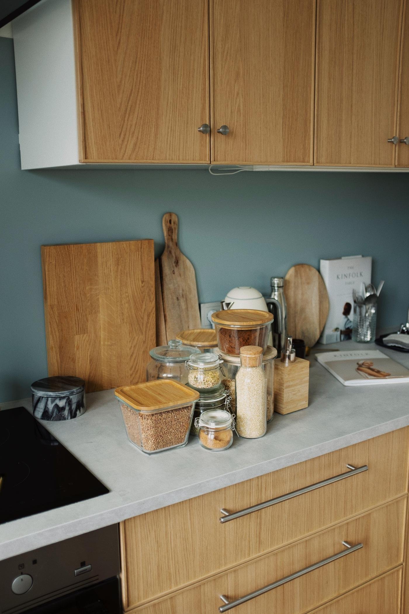 Organized kitchen counter with glass jars, wooden cutting boards, and pantry essentials
