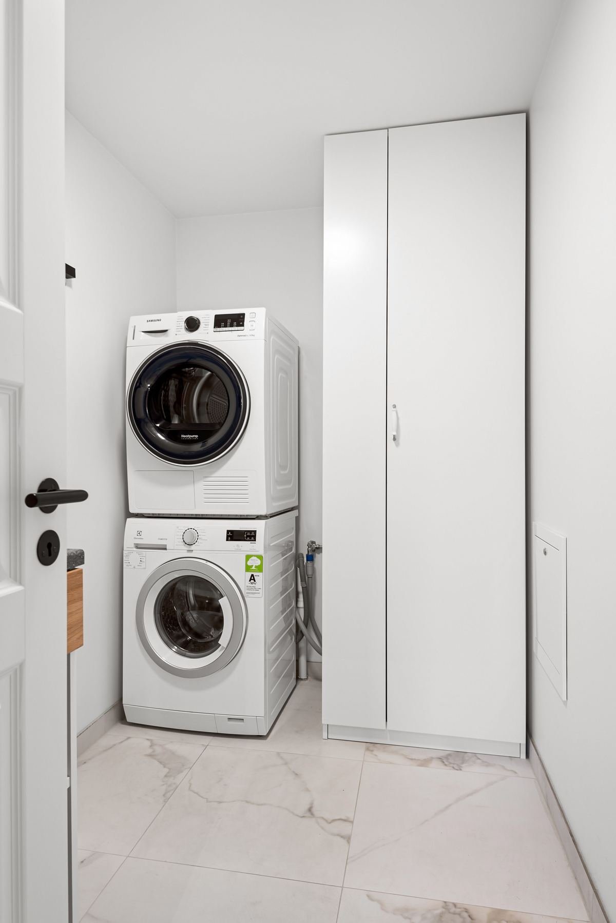 Small laundry room with organized storage and modern appliances