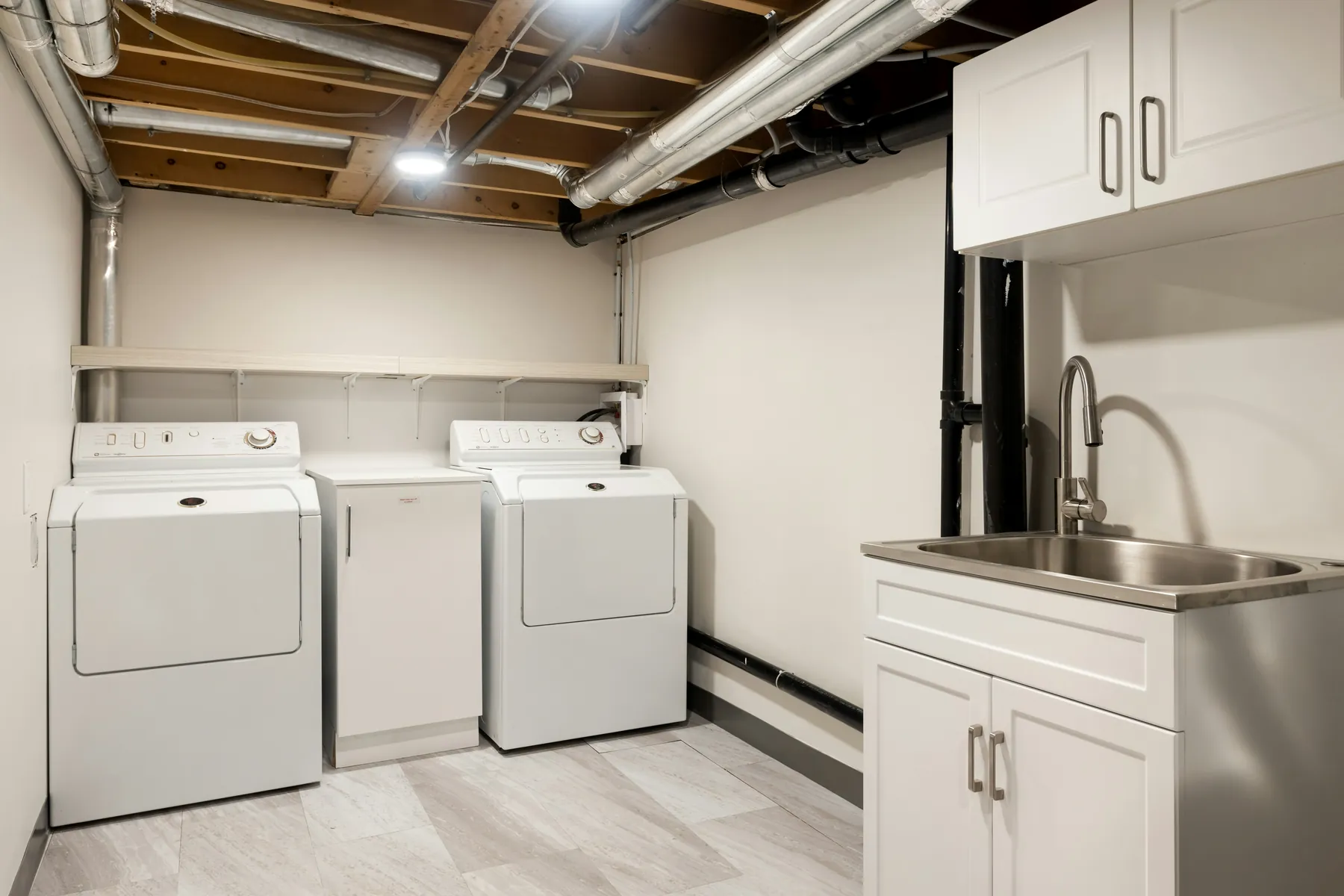Small laundry room with cabinets and storage