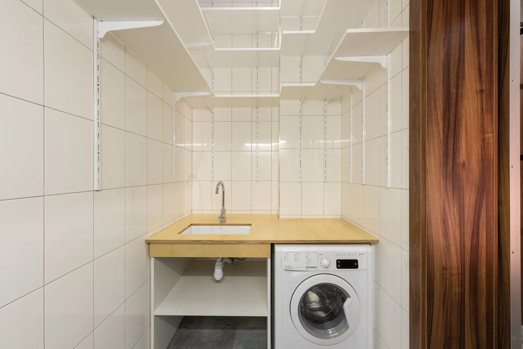 Small laundry room with open shelving and washing machine