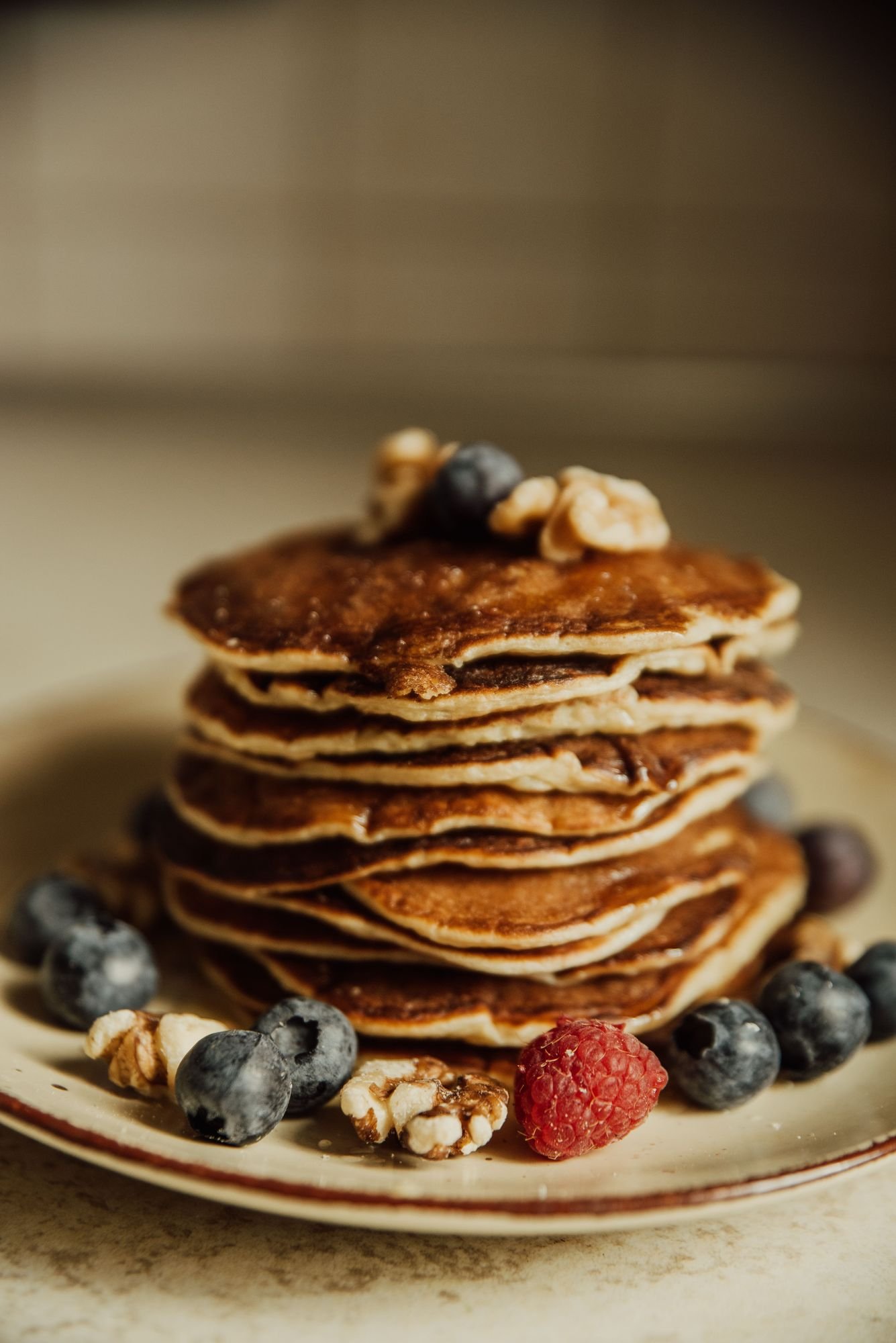 Whole-grain style pancakes topped with berries and walnuts