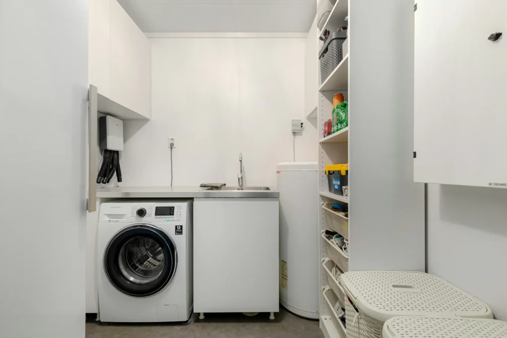 Laundry room with washer dryer and storage shelves